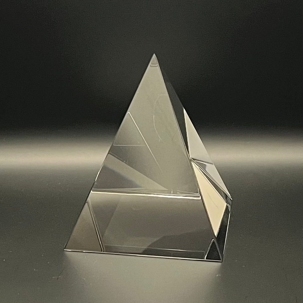 Clear pyramid-shaped object on a dark background