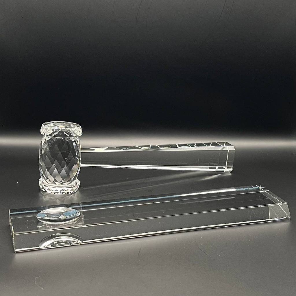 Set of crystal mace and crystal bar on a reflective surface with a dark background