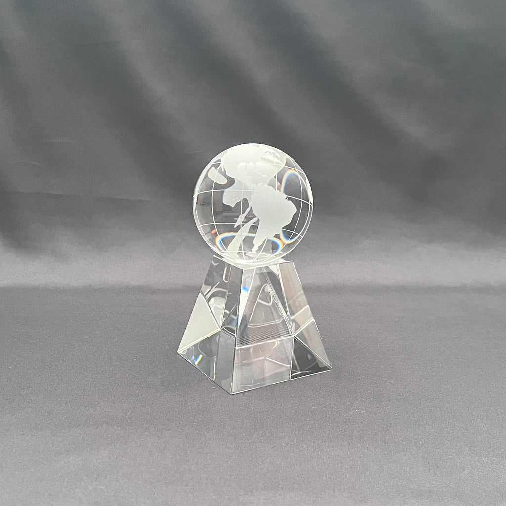 A clear glass decorative globe on a crystal base 