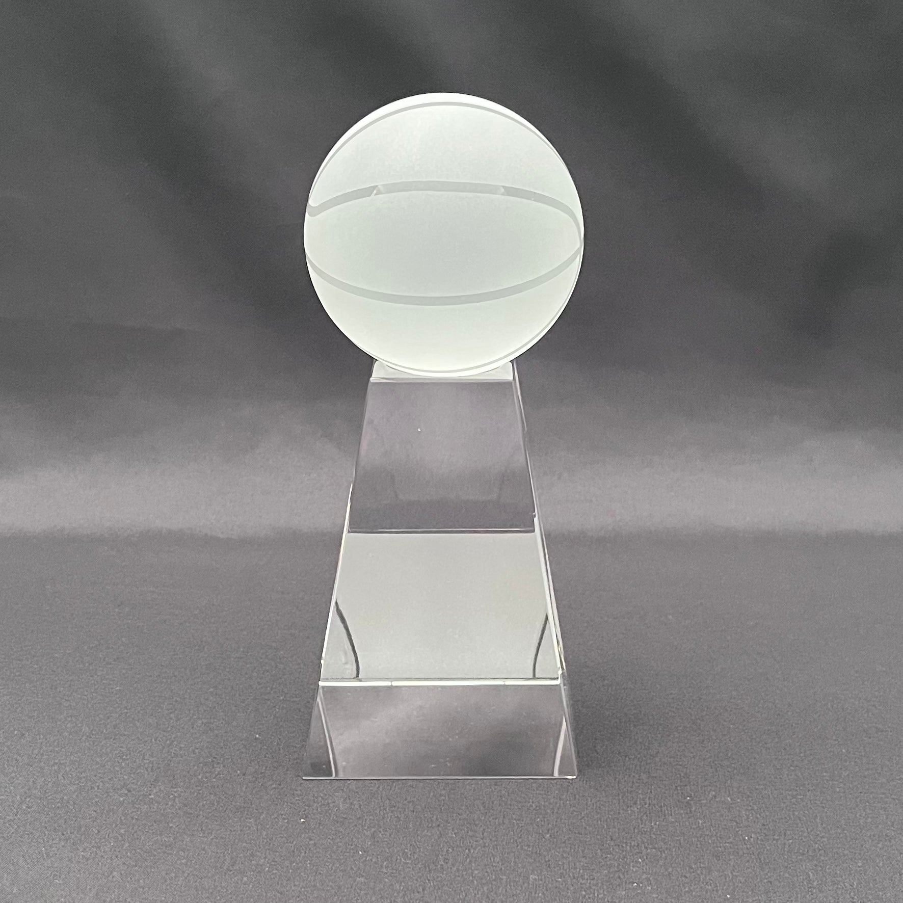 A clear acrylic trophy cup featuring a frosted glass ball on a tapered rectangular stand, 