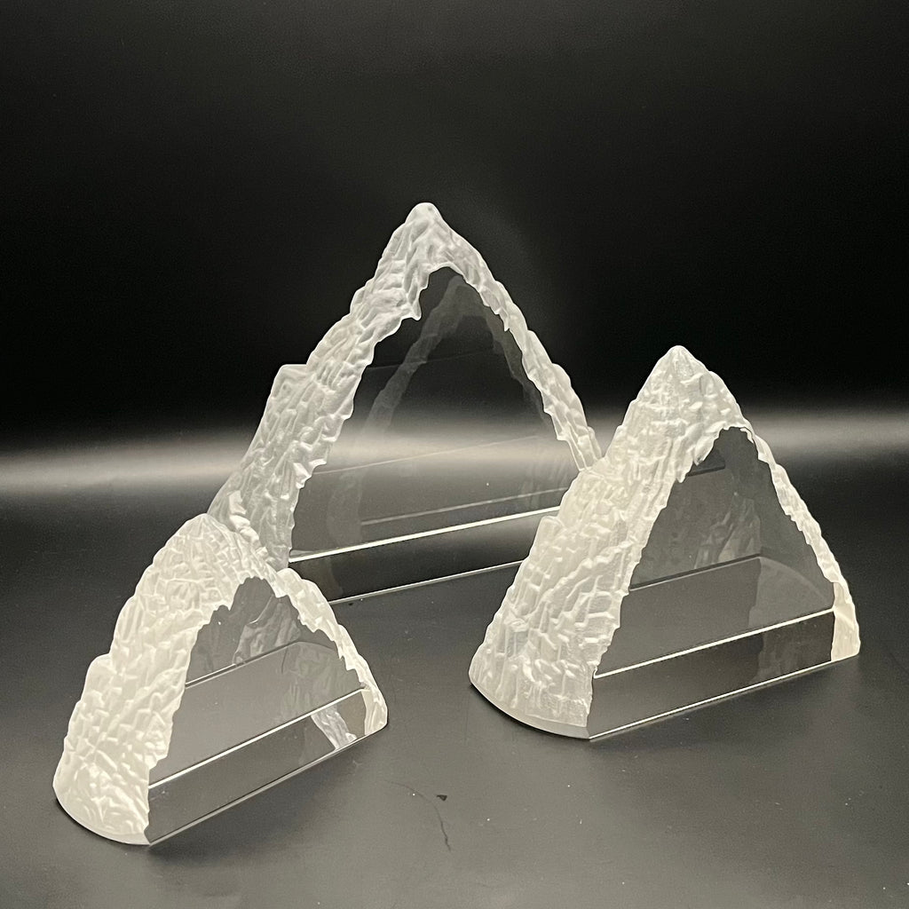 Two crystal Everest shaped awards on a dark background