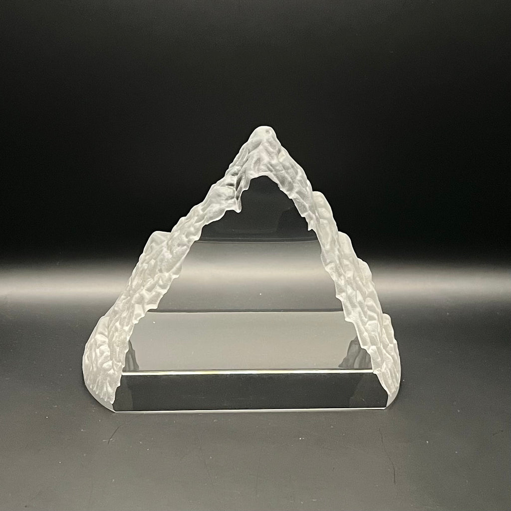 Clear crystal Everest -shaped object on a dark background