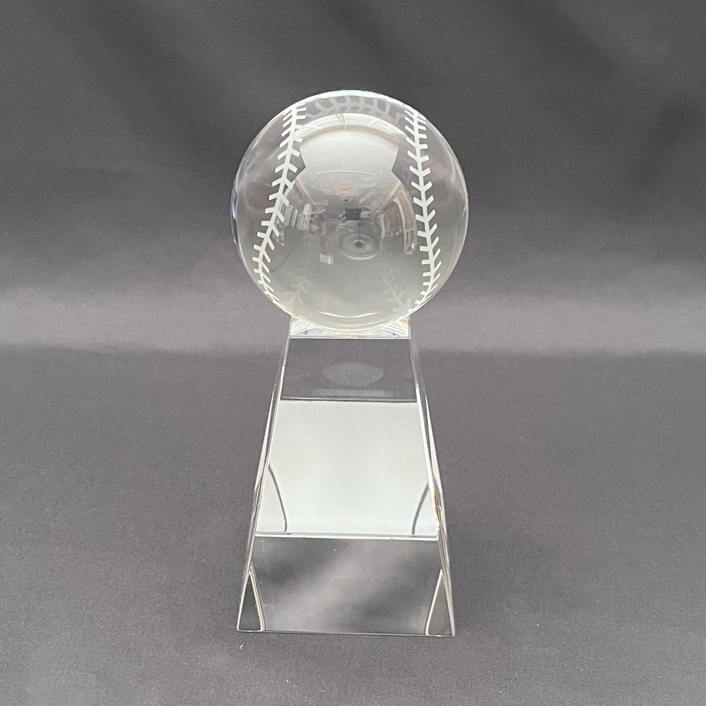 A clear crystal baseball trophy on a base 