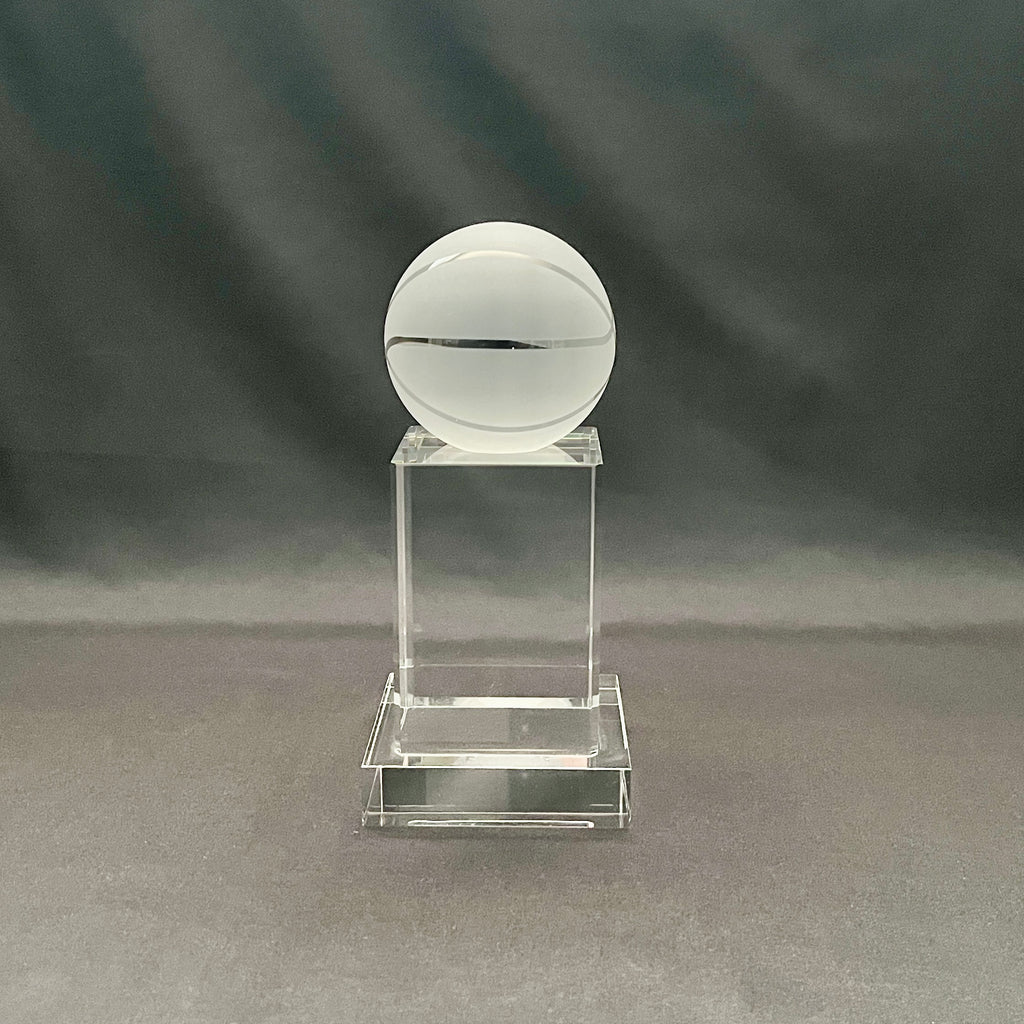 A clear acrylic trophy display stand featuring a frosted white crystal basketball on top.