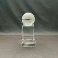 A clear acrylic trophy display stand featuring a frosted white crystal basketball on top.