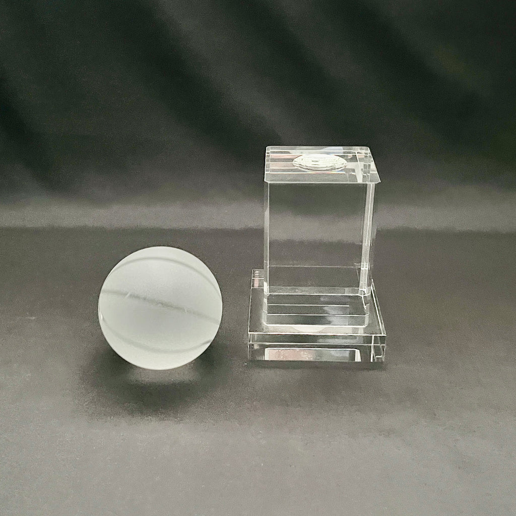 A clear crystal basketball on display stand.