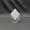 A clear acrylic geometric crystal award block with a diamond-shaped top and a multi-tiered base, 