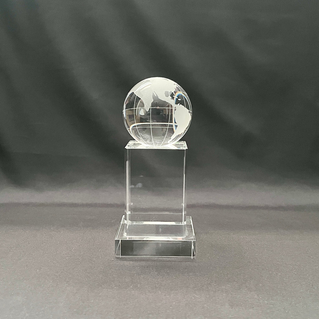 A clear crystal globe trophy on a matching rectangular pedestal base, 