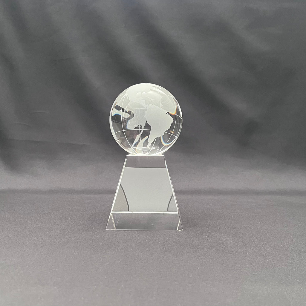A clear glass world globe trophy on a geometric stand 