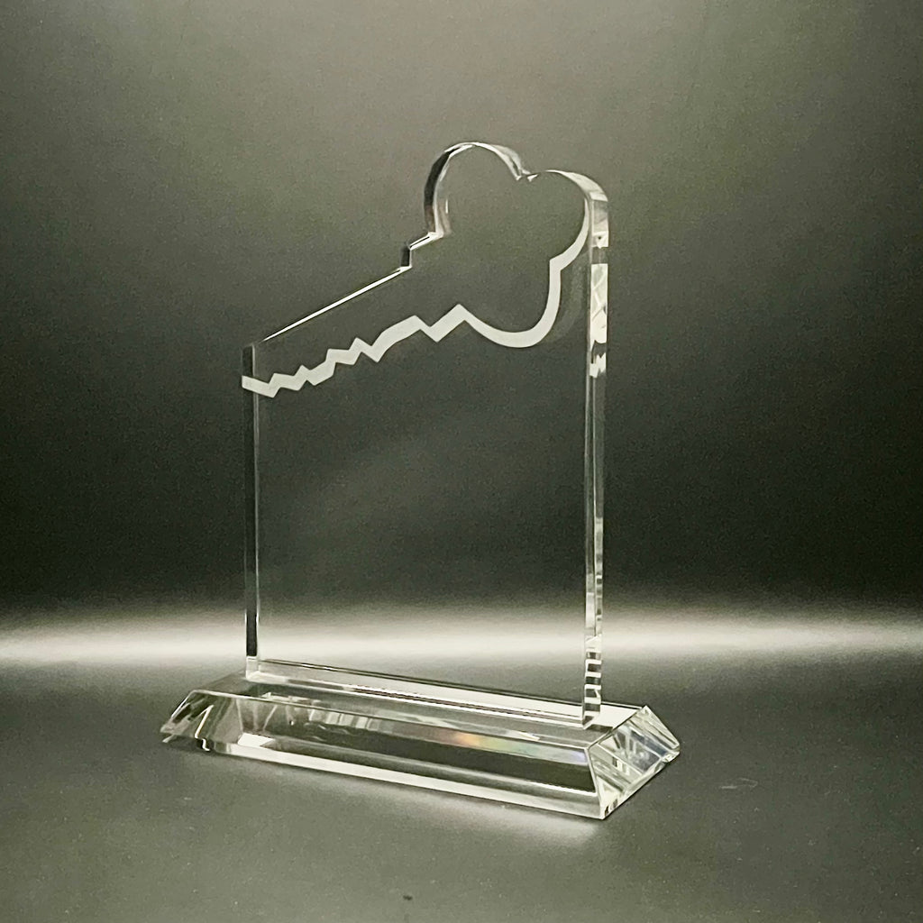 Clear crystal key-shaped award on a dark background