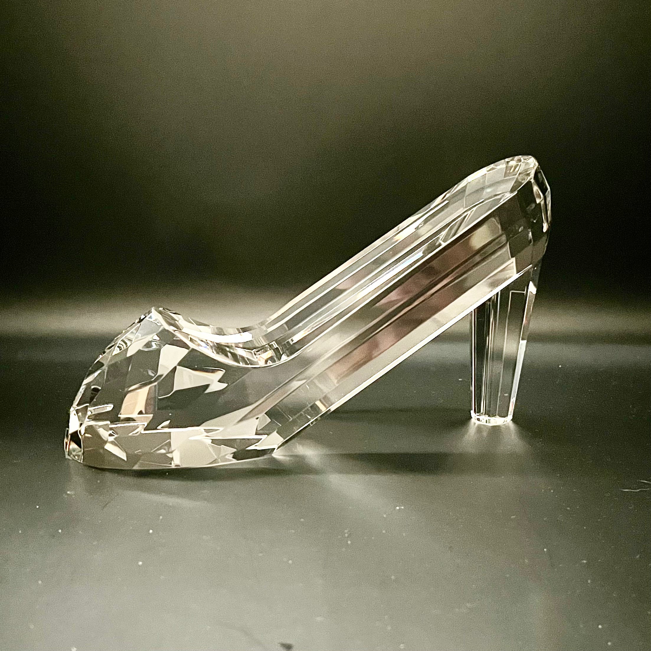 Clear crystal high-heeled shoe on a dark background