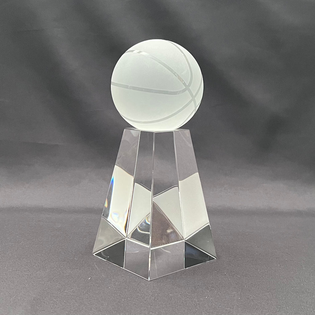 A clear glass trophy featuring a frosted glass basketball on a faceted, geometric glass pedestal.