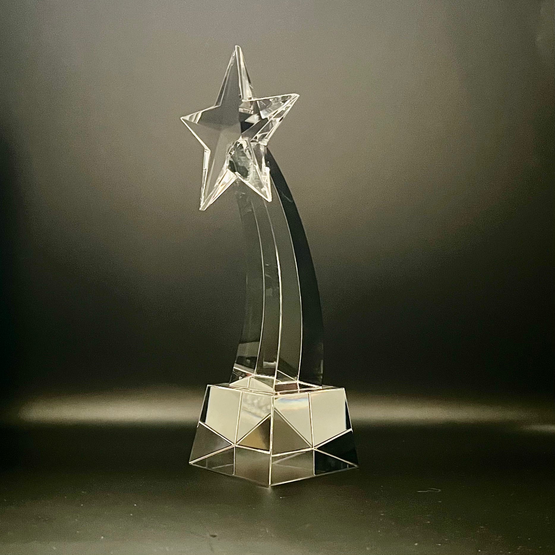 Clear crystal star-shaped trophy on a dark background