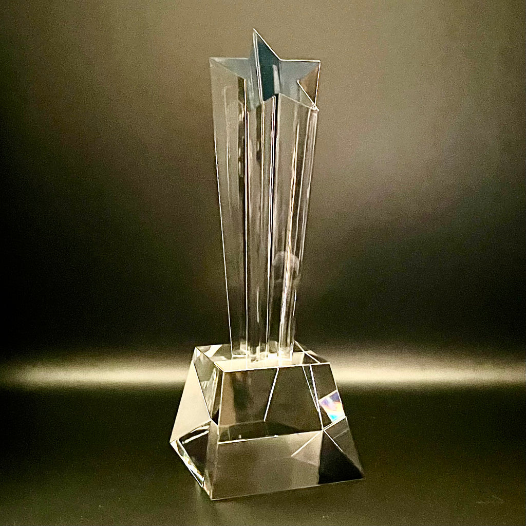 Clear crystal trophy with star design on a dark background