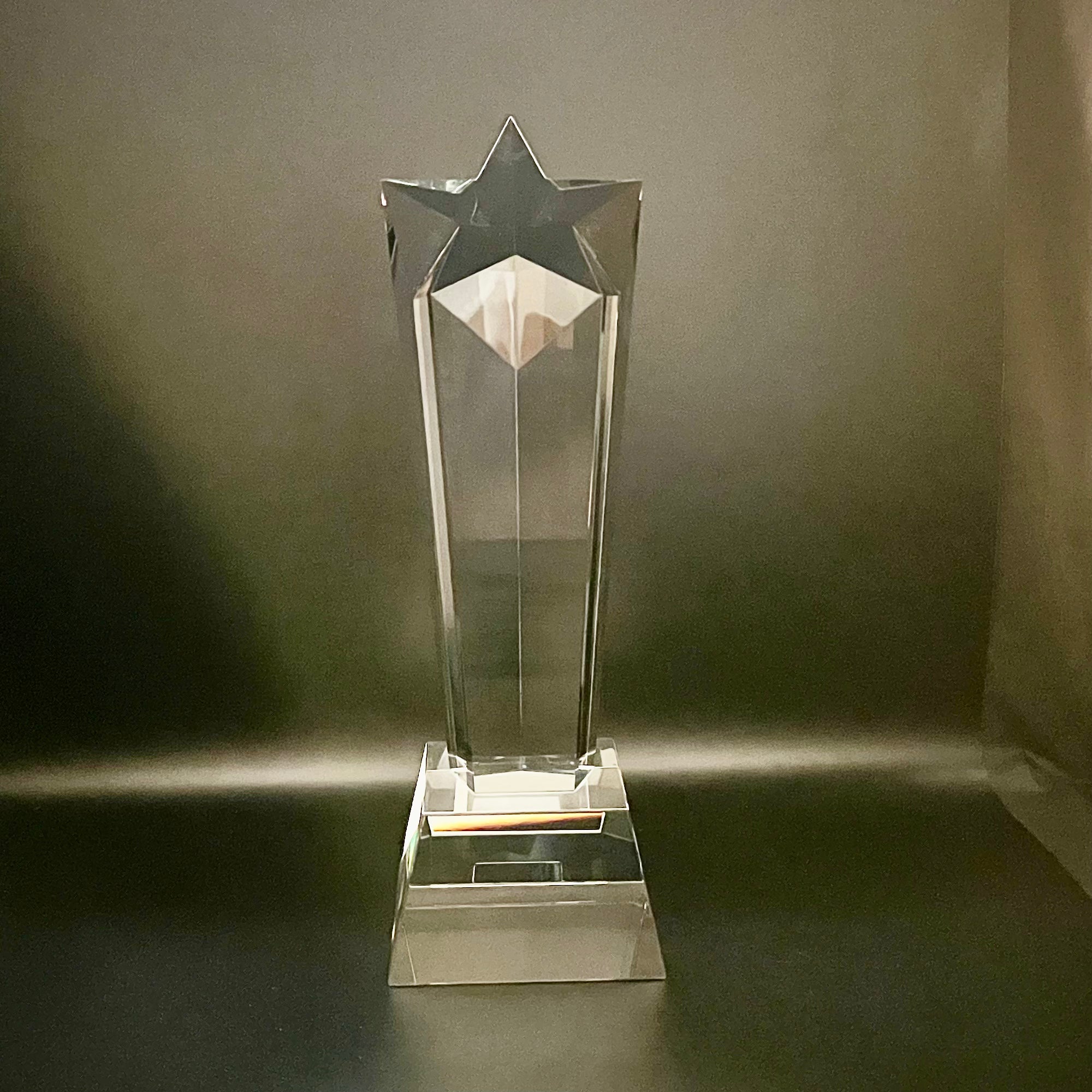 Clear glass star-shaped trophy on a dark background
