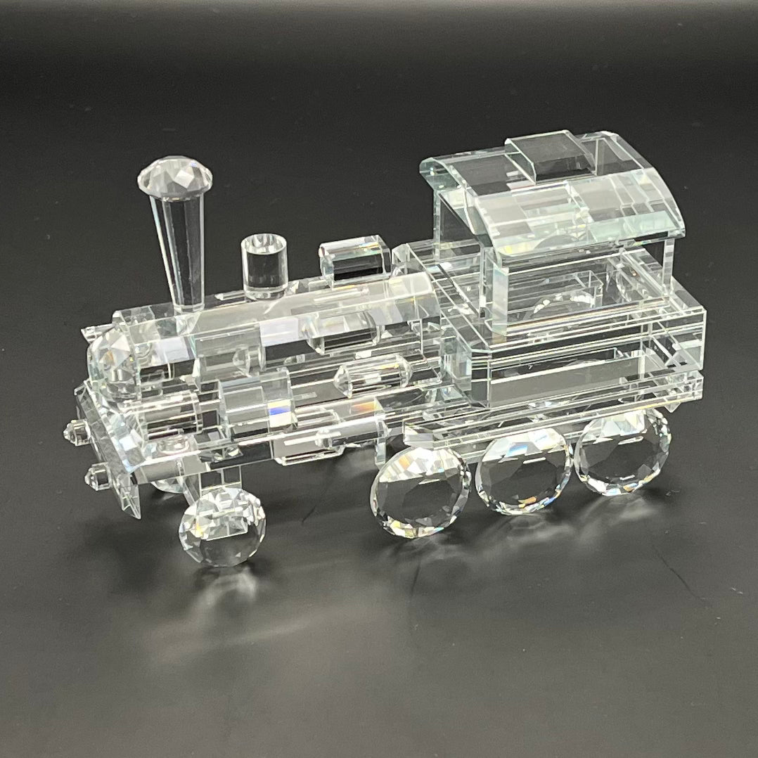 Clear crystal model of a train on a black background