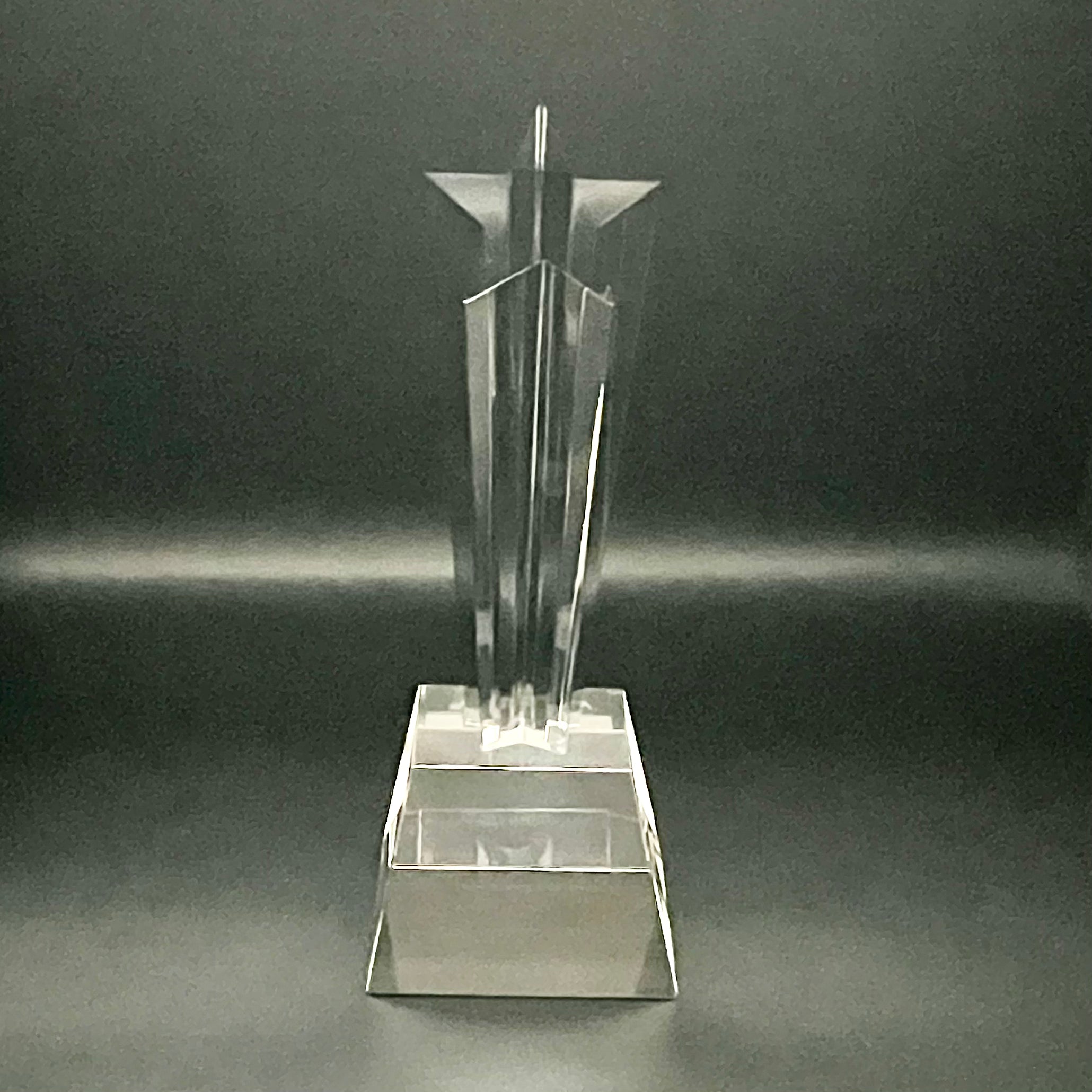 Clear crystal trophy on a dark gray background