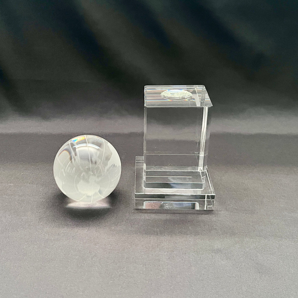 A clear crystal globe with a crystal stand 