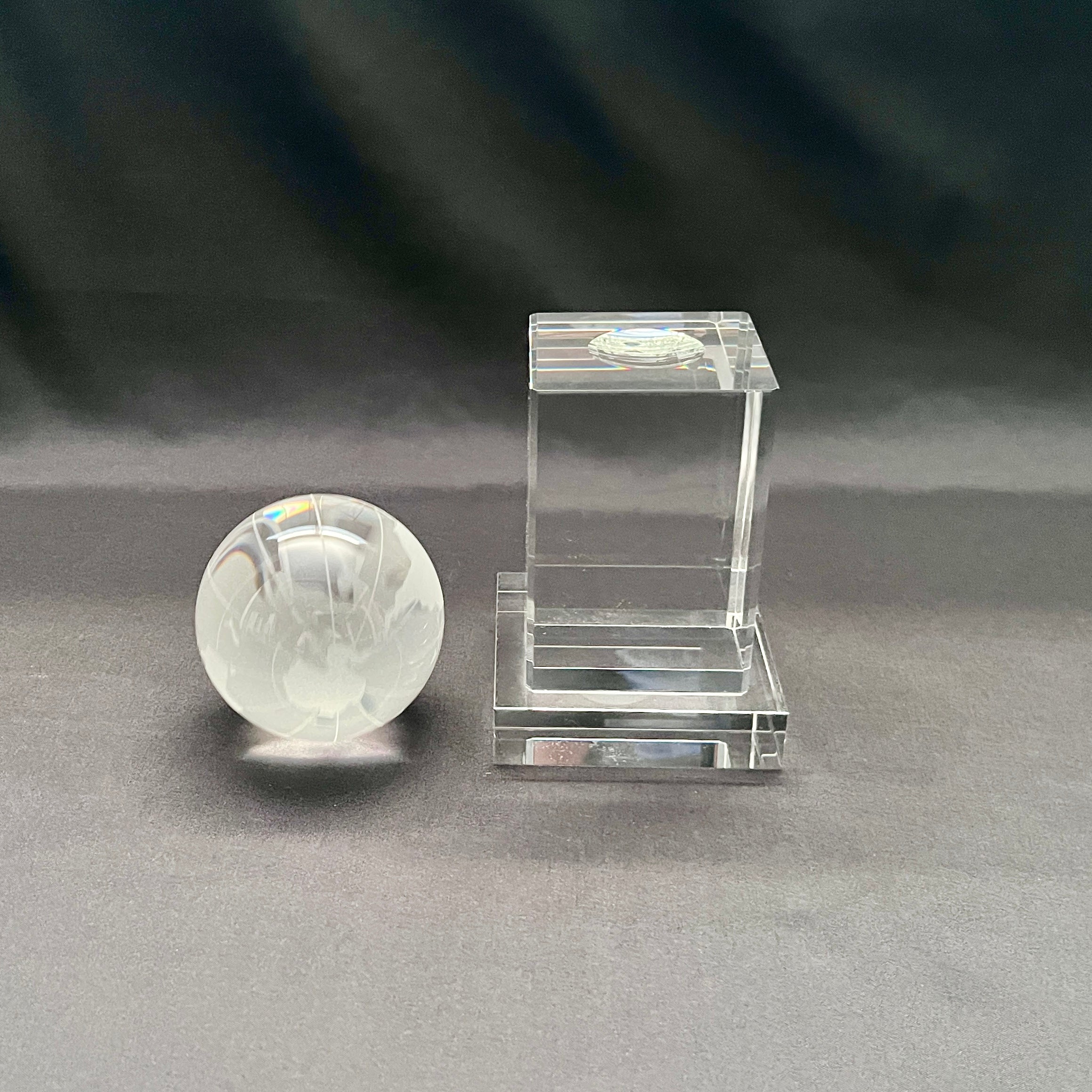 A clear crystal globe with a crystal stand 