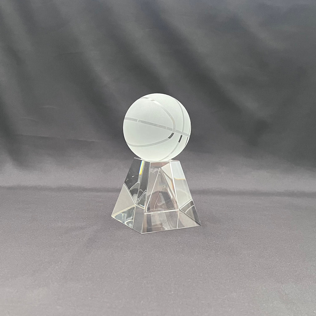A clear acrylic basketball trophy on a faceted base 