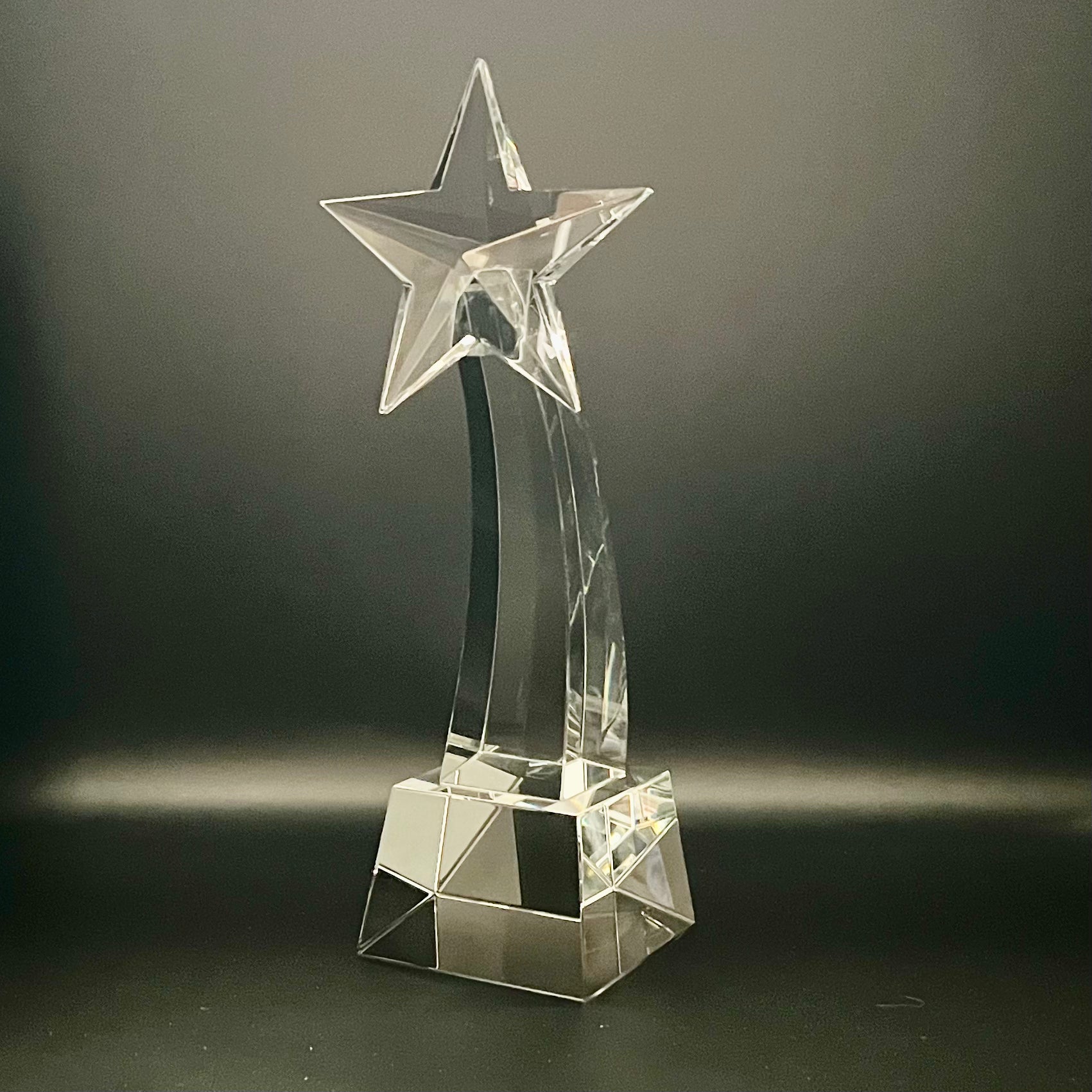 Clear crystal star-shaped trophy on a dark background