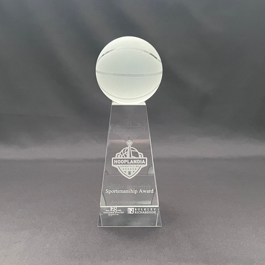 A clear acrylic sportsmanship award trophy featuring a spherical top and a tapered base engraved with the Hoop-landia Sportsmanship Award logo and text.