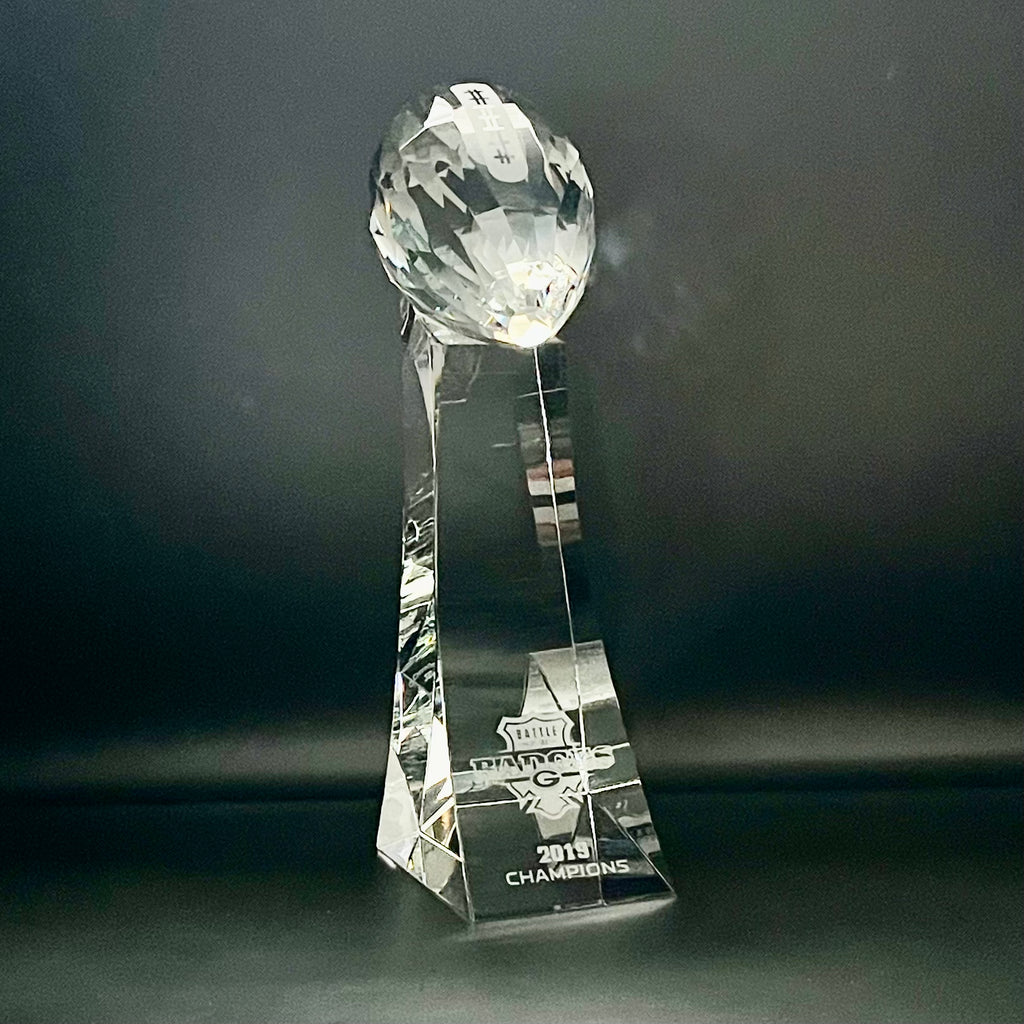 Crystal trophy with 'Champions' engraving on a dark background
