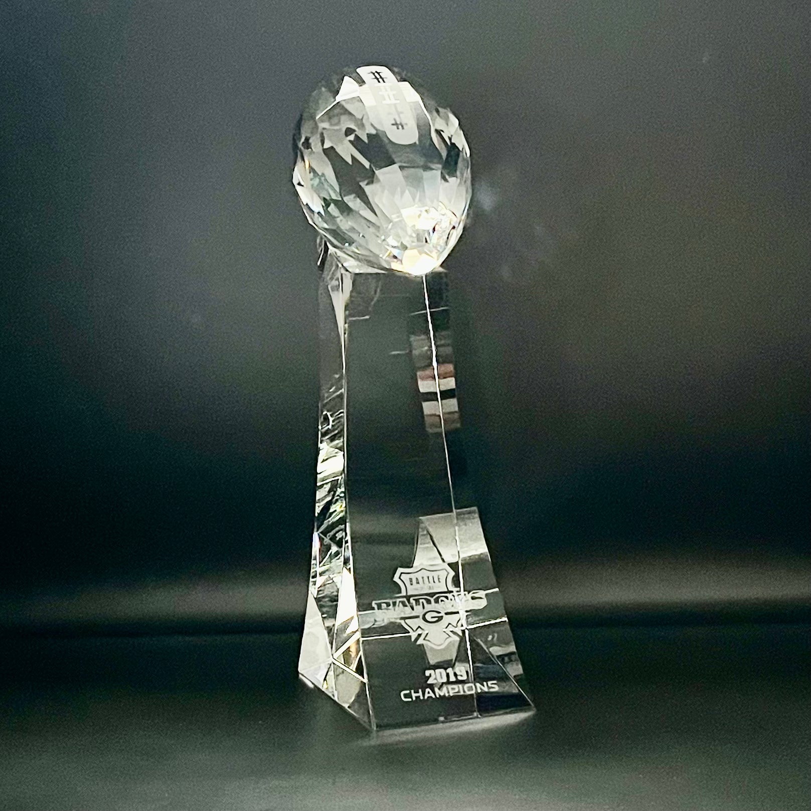Crystal trophy with 'Champions' engraving on a dark background