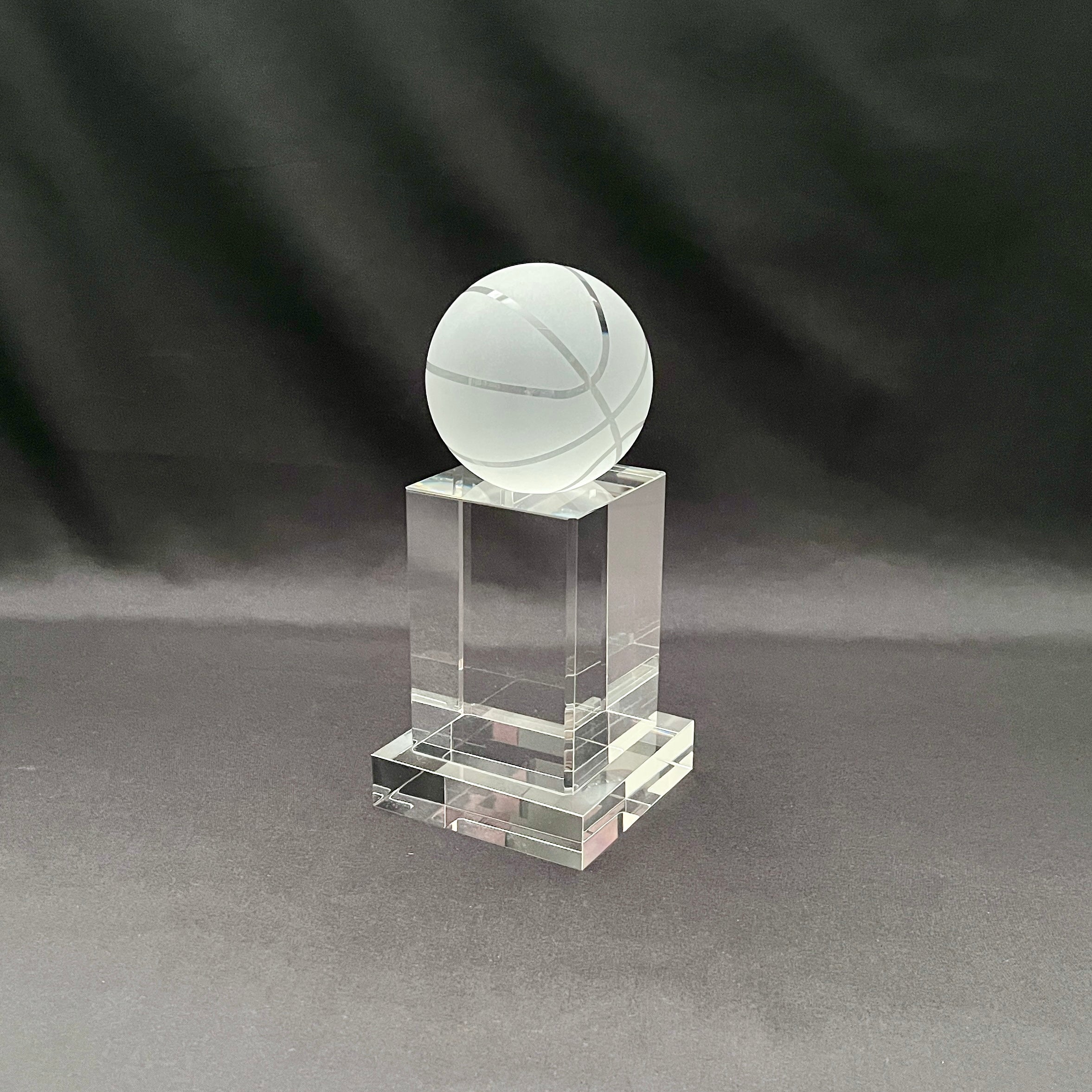 A clear acrylic trophy stand featuring a frosted white basketball ornament