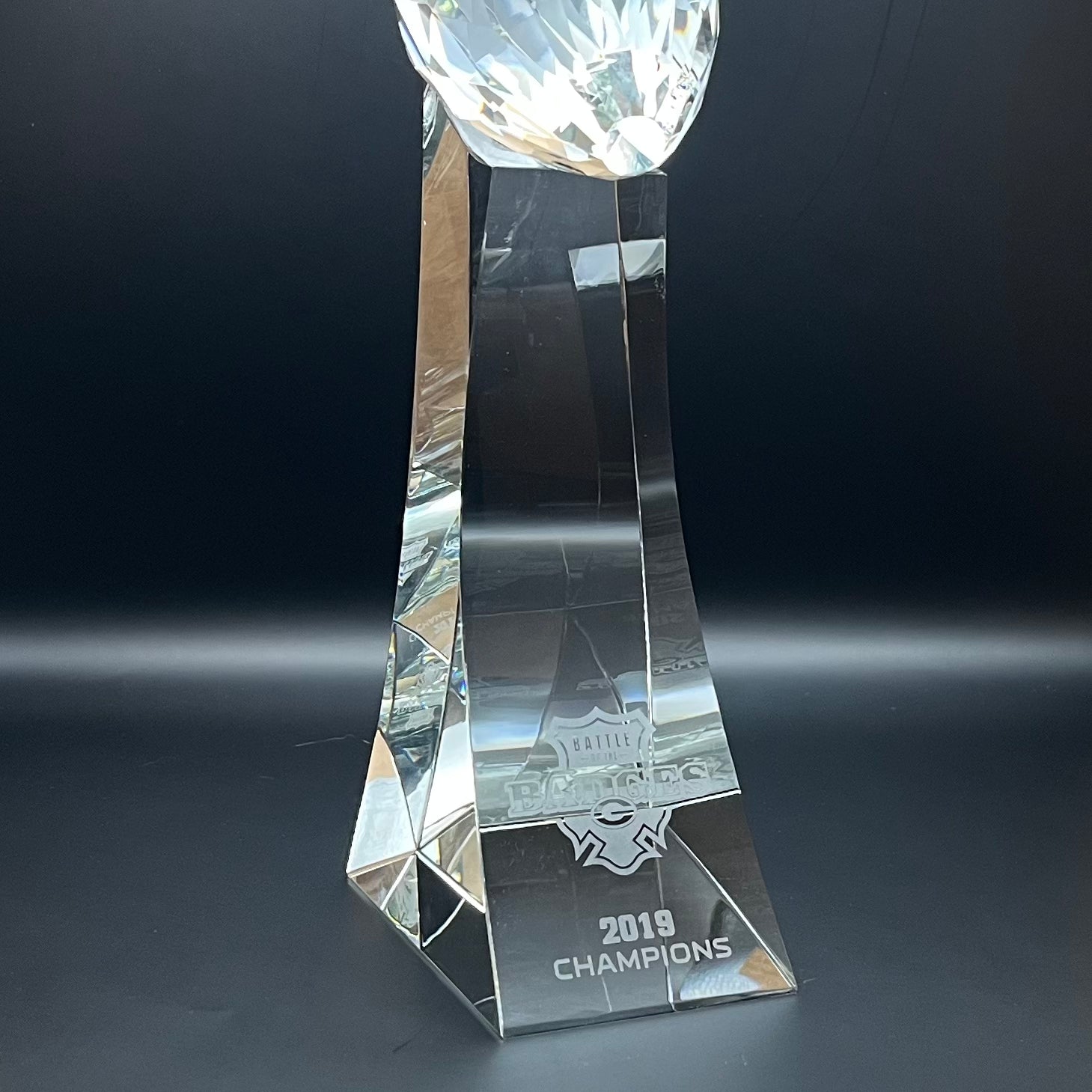 Crystal trophy with '2019 Champions' inscription on a dark background