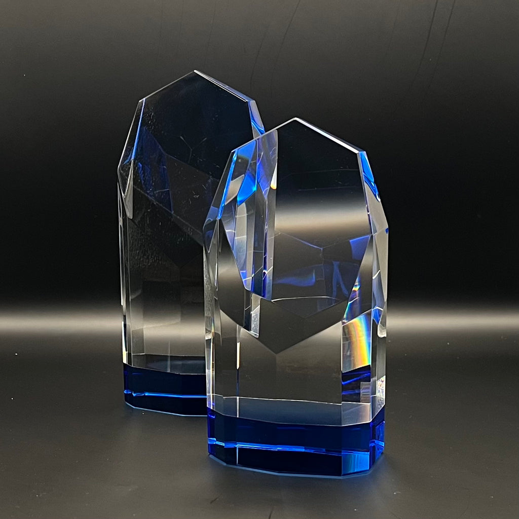 Two faceted crystal objects with blue accents on a dark background